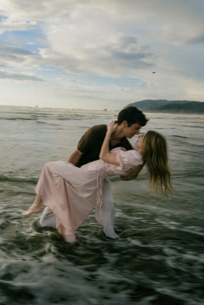 Simon dipping Francesca in the ocean waves