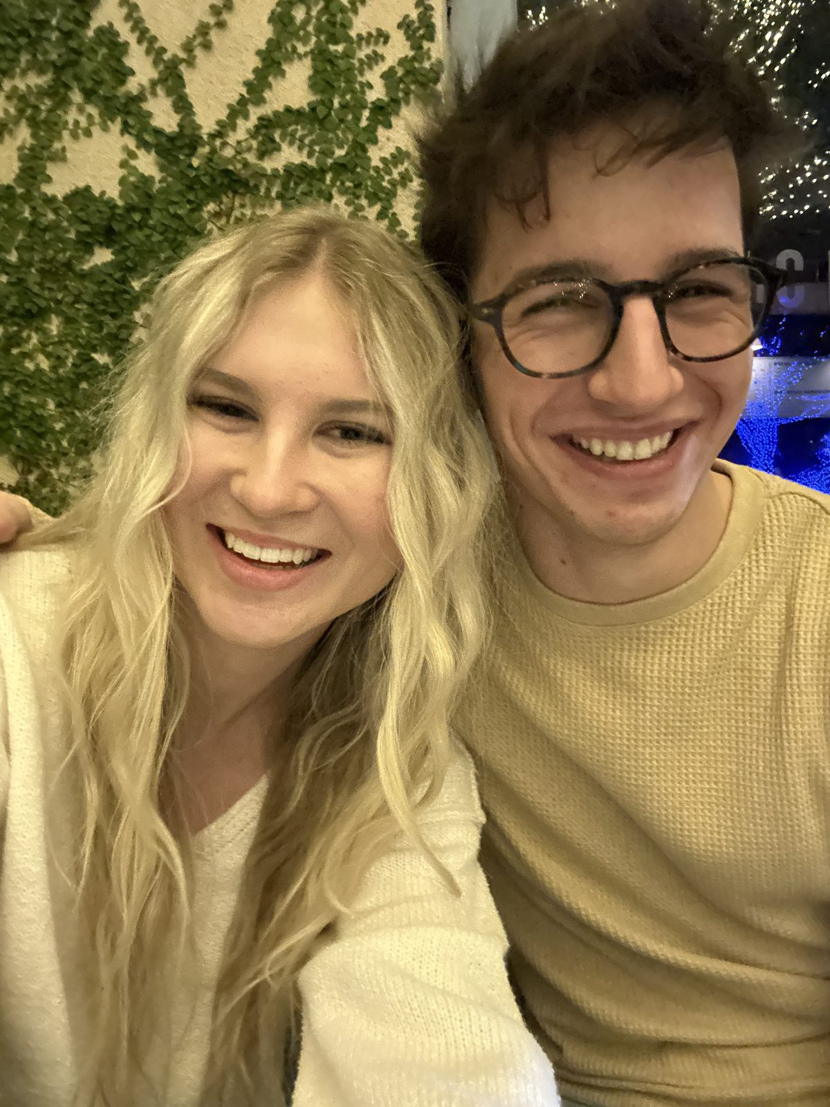 Simon and Francesca smiling in front of an ivy wall in Highland Park, Dallas, just after Christmas